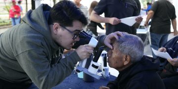 Personal de salud examina los ojos de un adulto mayor durante una jornada de atención visual.