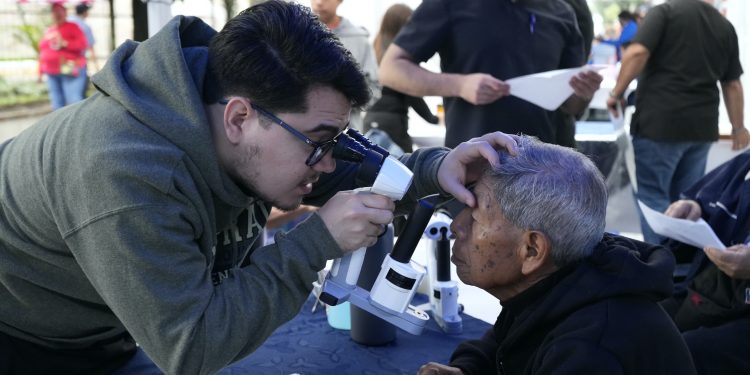 Personal de salud examina los ojos de un adulto mayor durante una jornada de atención visual.