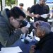 Personal de salud examina los ojos de un adulto mayor durante una jornada de atención visual.