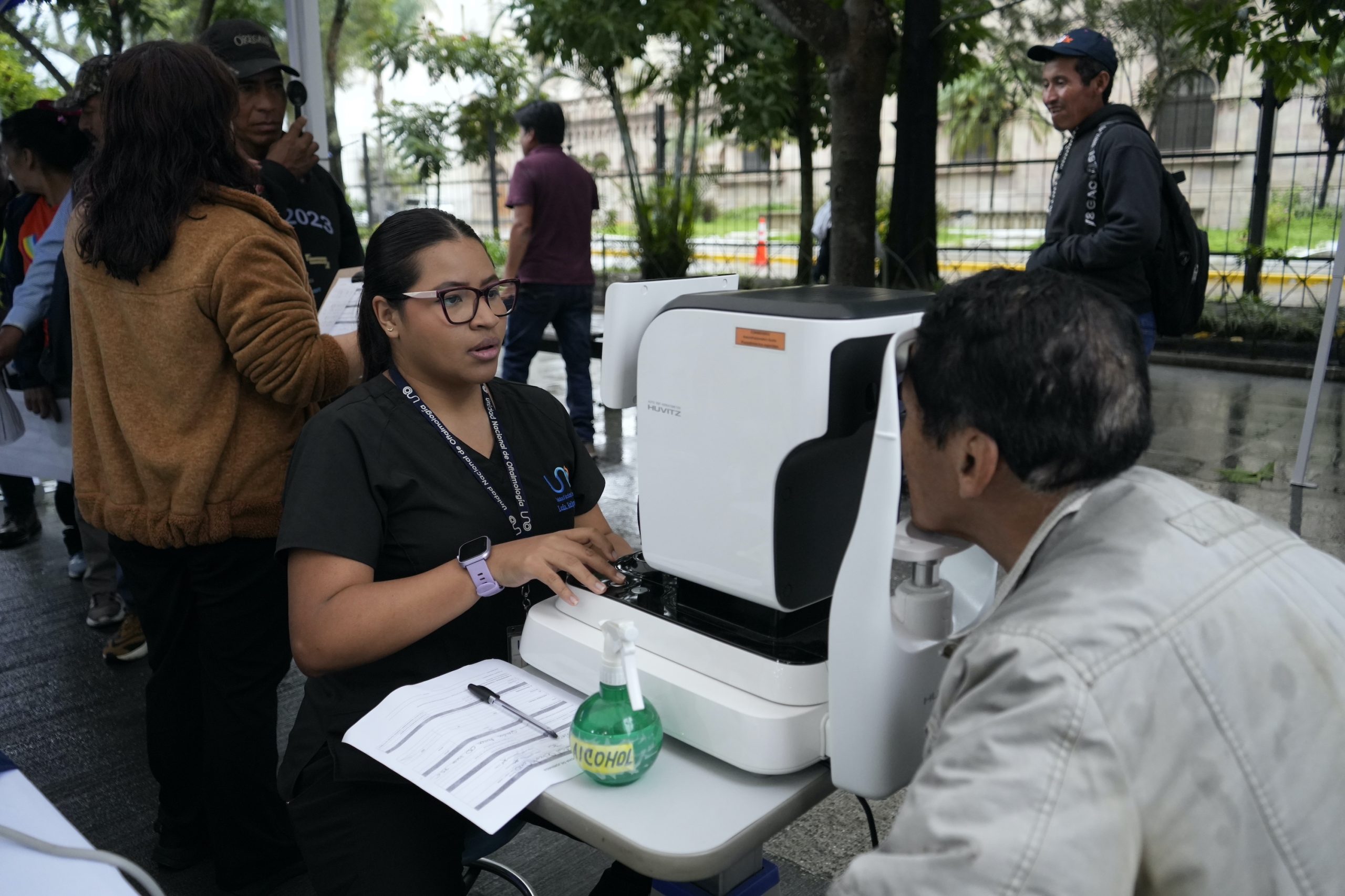 Personal de salud realiza una evaluación visual a un hombre con equipo especializado.