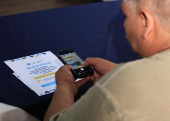 Usuario escanea con su teléfono celular un código QR de material informativo de la DGT.
