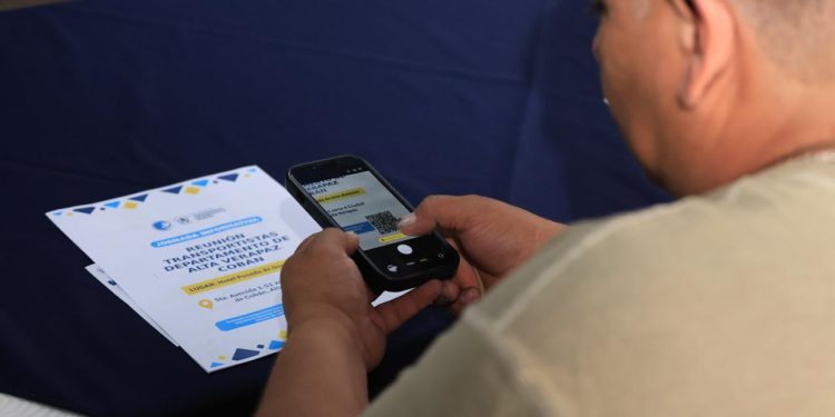 Usuario escanea con su teléfono celular un código QR de material informativo de la DGT.