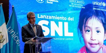 Joaquín Barnoya habla desde un atril frente a una pantalla que anuncia el lanzamiento del suplemento nutricional lipídico.